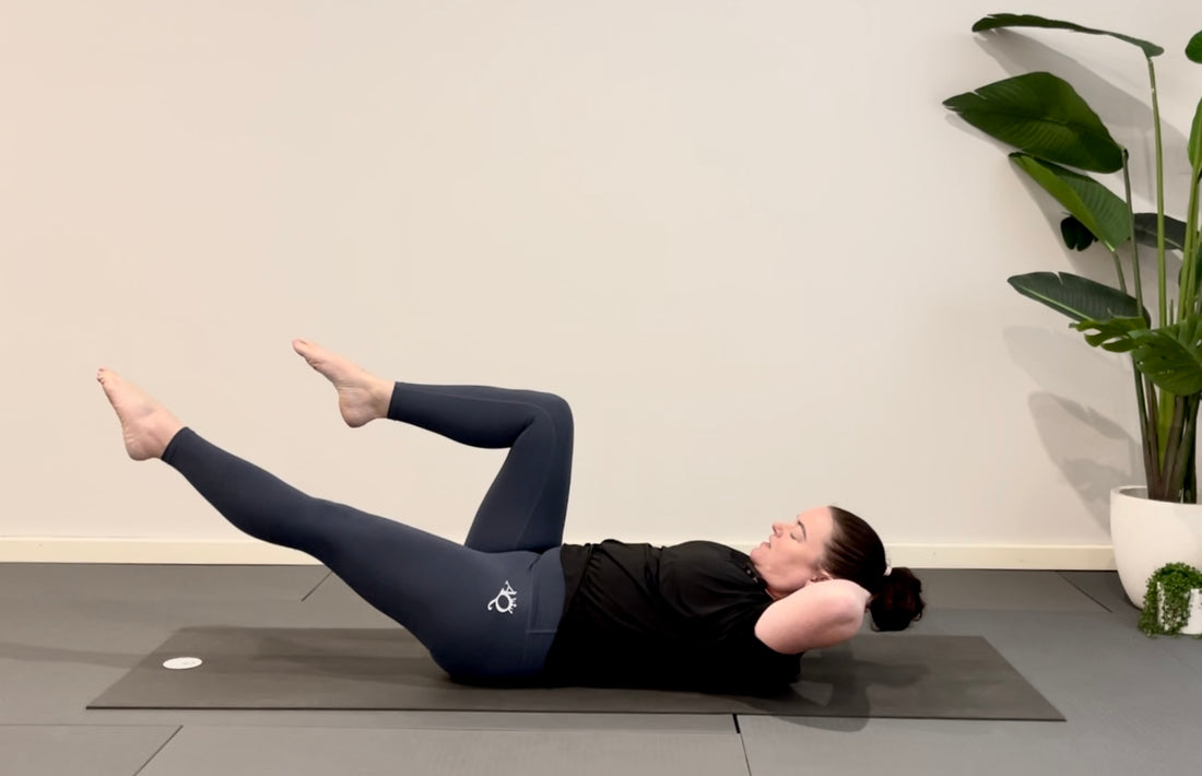 Woman doing Pilates in blue high waisted leggings and black tee