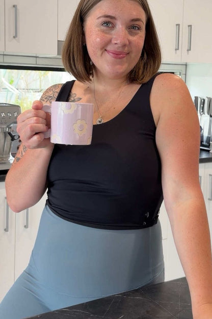 Woman holding a mug in a kitchen